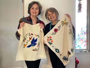 Barbara Romero Alba and Julia R. Gomez show their hand-sewn embroidery projects, that are now in Trinidad, Cuba to be completed by Zobeida Gonzalez and Obdulia Gonzalez.